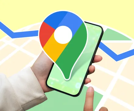 A person holding a smartphone with the Google Maps logo enlarged over the screen set against a stylized map background with a blue navigation route line running across it